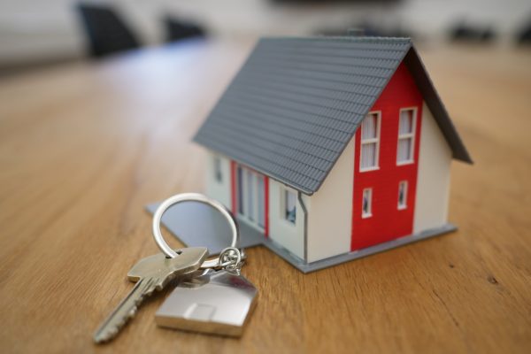 picture of a small keyring in the shape of a house on a table