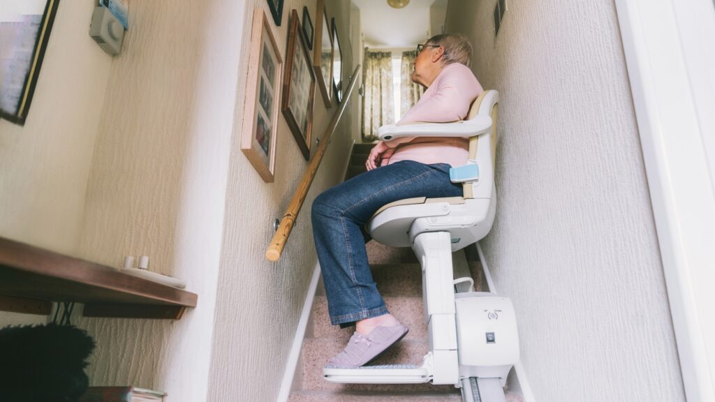 elderly woman using stairlift at home