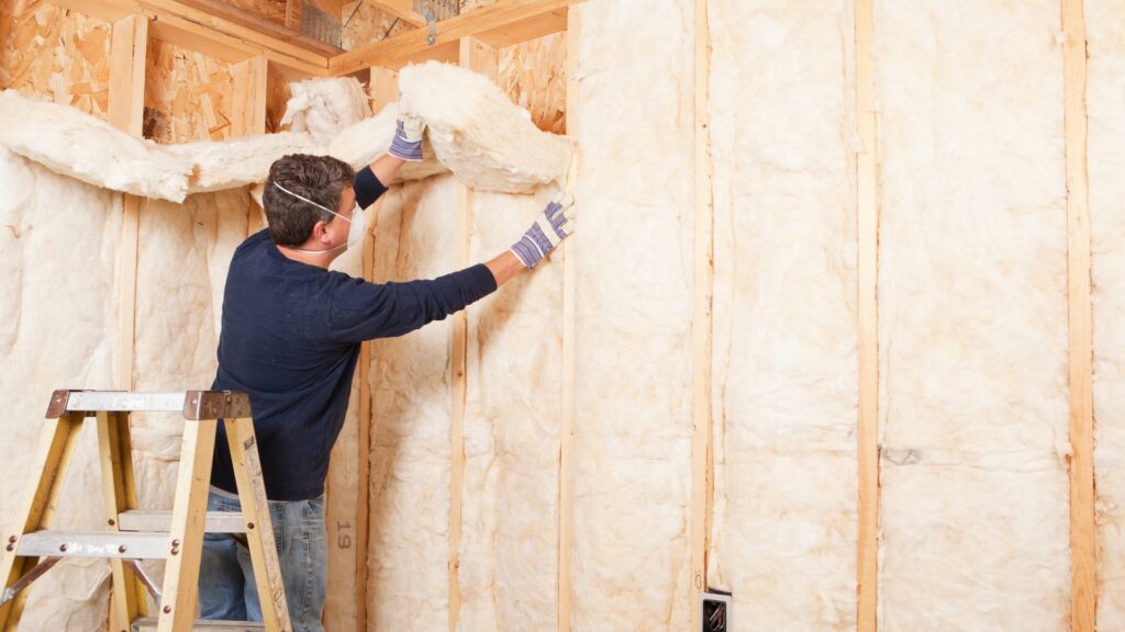 man applying wall insulation